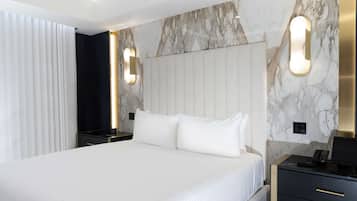 A modern hotel room with a large bed, marble wall, and bedside tables with lamps.