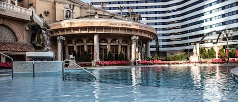 A pool area with a circular building labeled 'Bimini Steakhouse' and a modern high-rise building in the background.