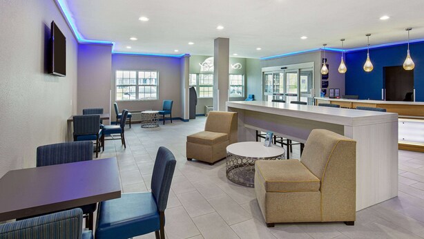 A modern hotel lobby with a bar area, seating arrangements, and a large window providing natural light. - Microtel Inn & Suites by Wyndham Manchester (Manchester)