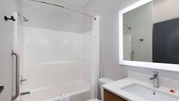 Uma casa de banho moderna com banheira, chuveiro, sanita e lavatório.