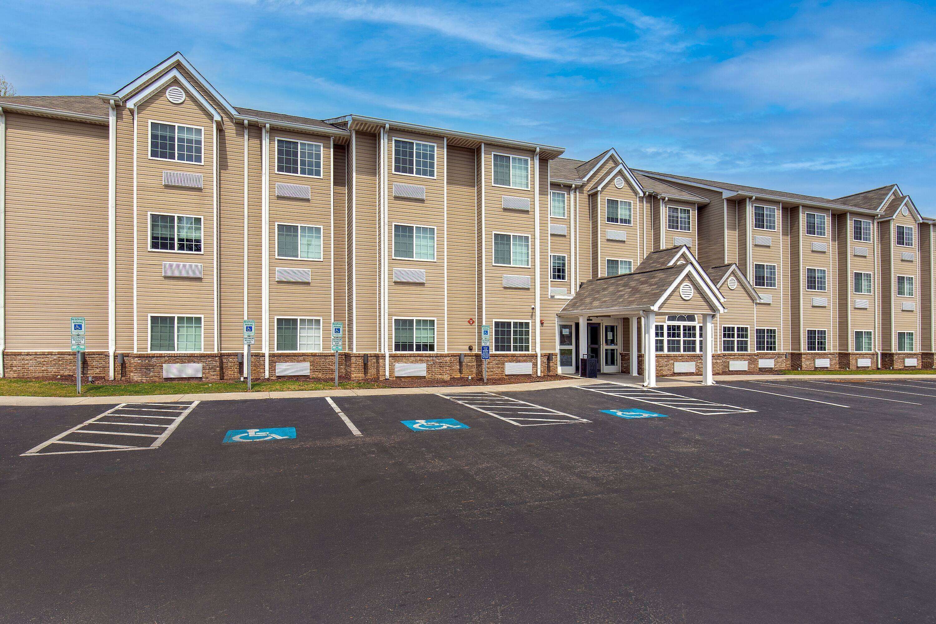 A multi-story building with a parking lot in front, including handicapped parking spaces.