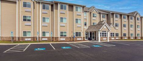 A multi-story building with a parking lot in front, including handicapped parking spaces.