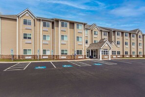 A multi-story building with a parking lot in front, including handicapped parking spaces. - Microtel Inn & Suites by Wyndham Manchester (Manchester)