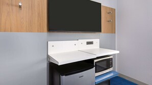 A kitchenette with a microwave, a small refrigerator, and a white countertop. - Microtel Inn & Suites by Wyndham Manchester (Manchester)
