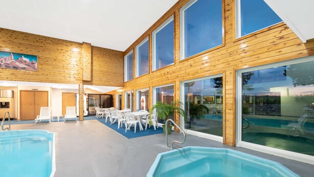 Une piscine intérieure avec des murs en bois et de grandes fenêtres.