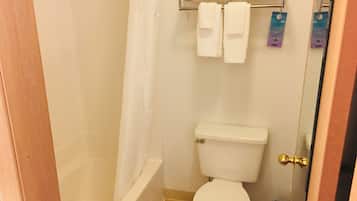A bathroom with a toilet, a shower, and a towel rack with towels.