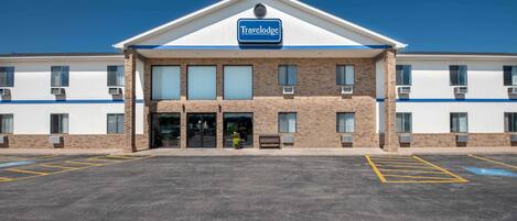 A Travelodge hotel with a flat roof, large windows, and a parking lot with marked spaces.