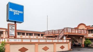 Un motel con un letrero destacado que dice "RODEWAY INN" y un letrero adicional que indica "ABIERTO TODO EL AÑO".