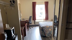A hotel room with a bed, desk, chair, and a large mirror. - Amelia Inn & Suites (Amelia Court House)
