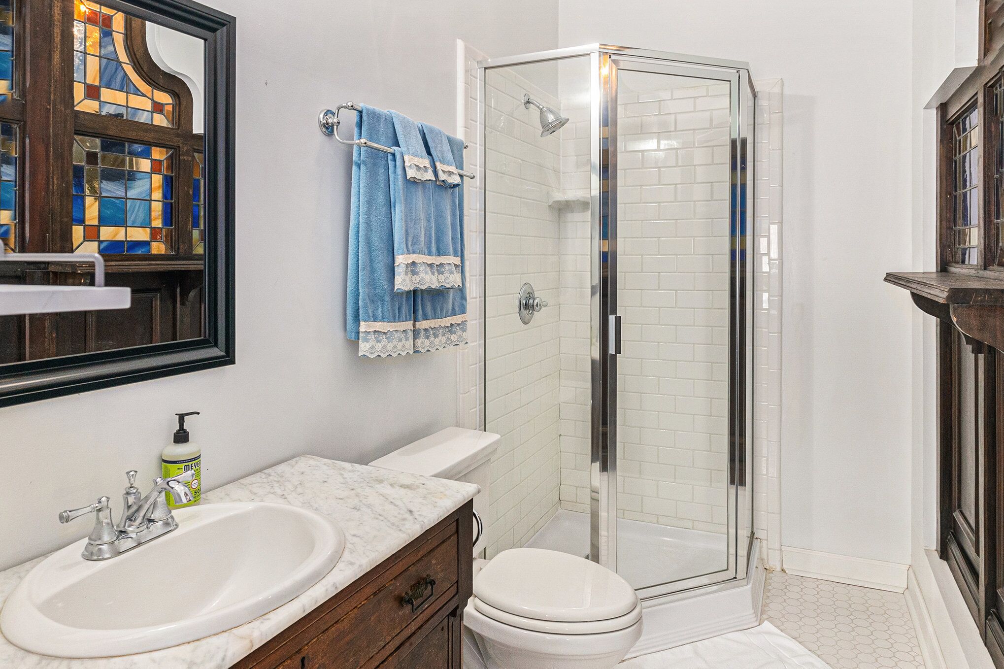 A bathroom with a white sink, a toilet, and a glass-enclosed shower.