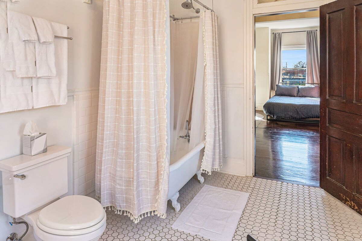 A bathroom with a toilet, bathtub, and shower curtain.