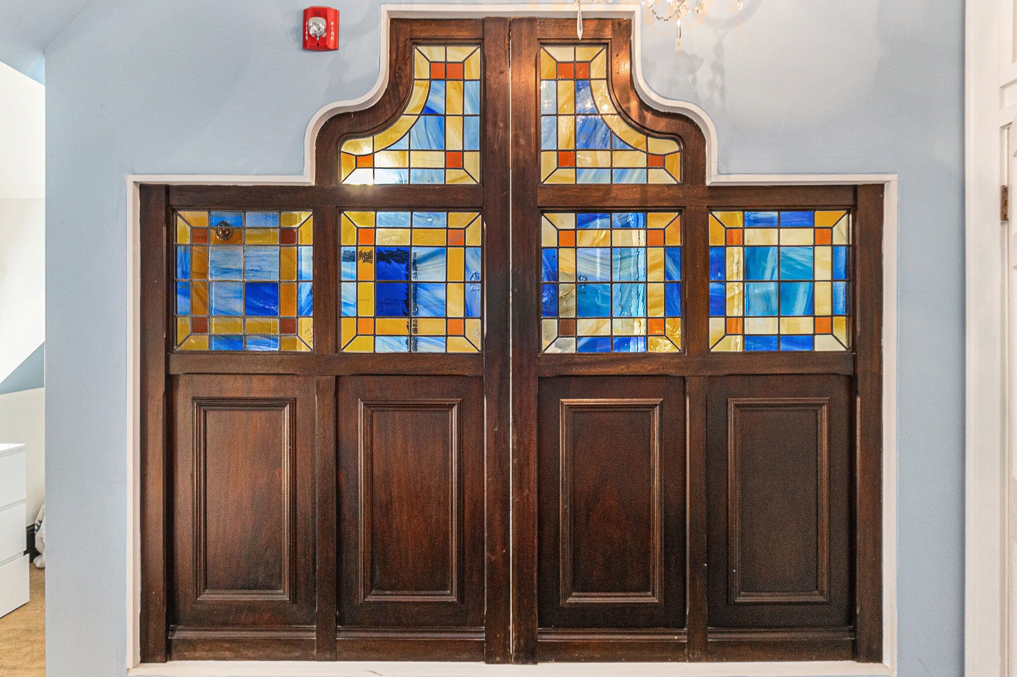 Une porte en bois ornée de panneaux de vitrail.