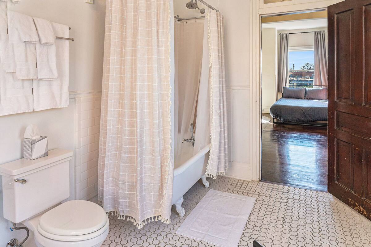 Une salle de bain équipée de toilettes, d’une baignoire et d’un rideau de douche.