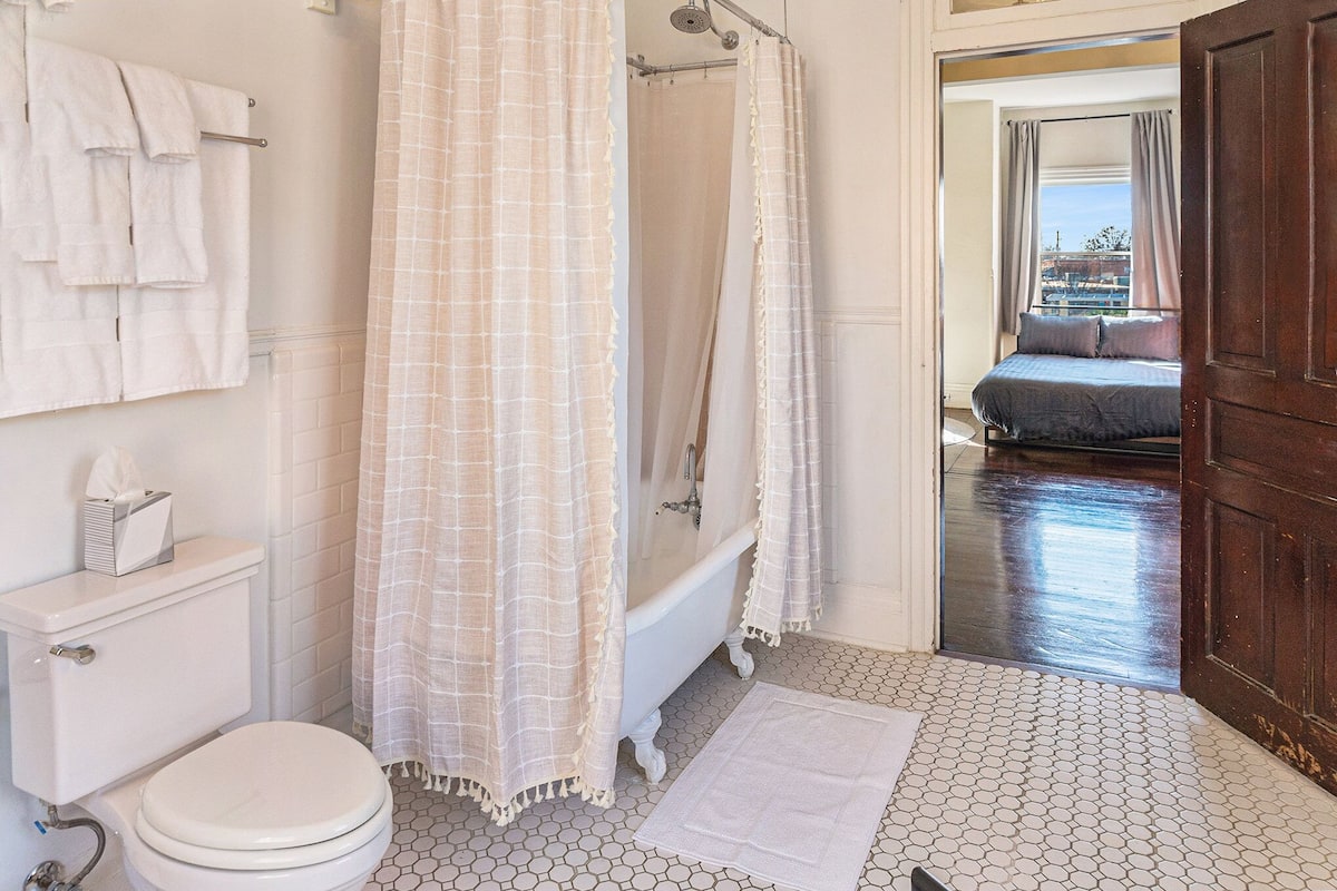 A bathroom with a toilet, bathtub, and shower curtain.