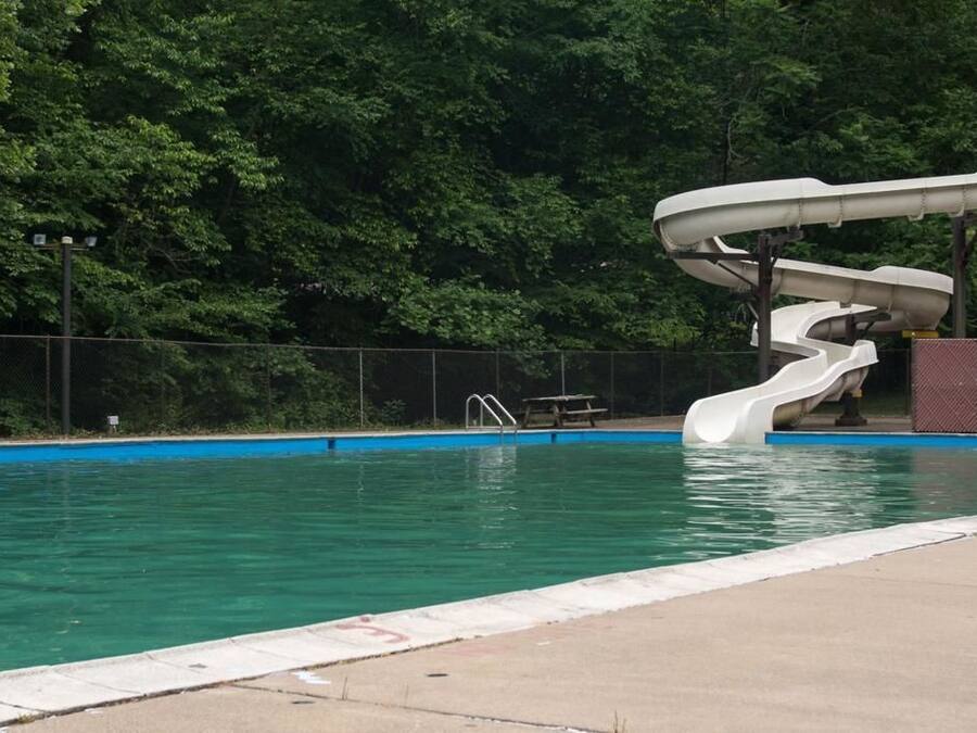 En swimmingpool med vandrutsjebaner og en stige.
