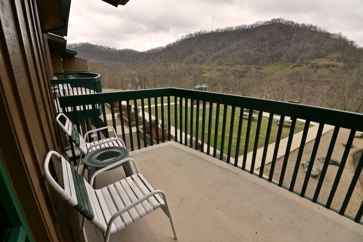 A balcony with a view of a forested hillside.