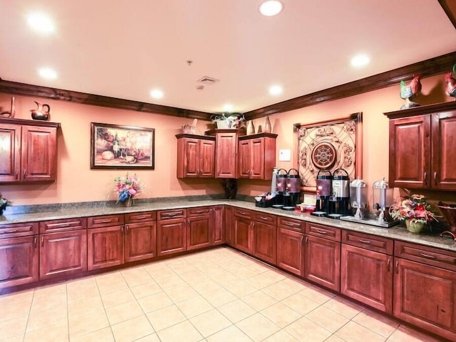 A spacious kitchen with wooden cabinets, a granite countertop, and various appliances.