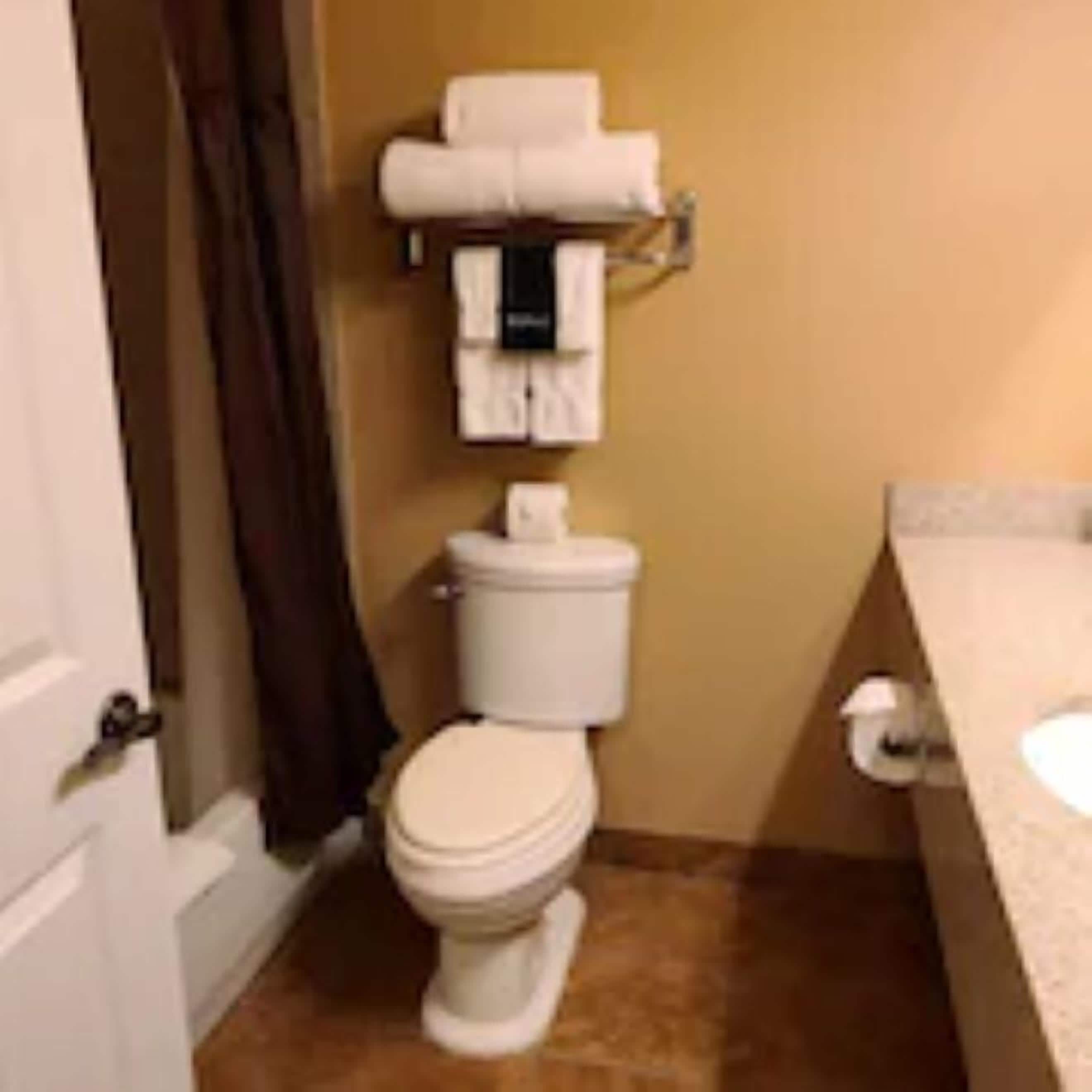 Ein kleines Badezimmer mit Toilette, Handtuchhalter und Waschbecken.