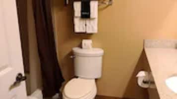 A small bathroom with a toilet, a towel rack, and a sink.