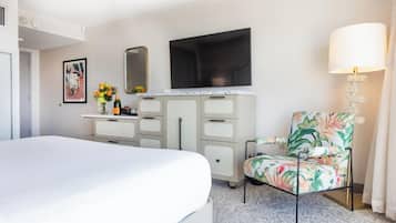 A hotel room with a bed, a dresser, a television, a chair, and a lamp.