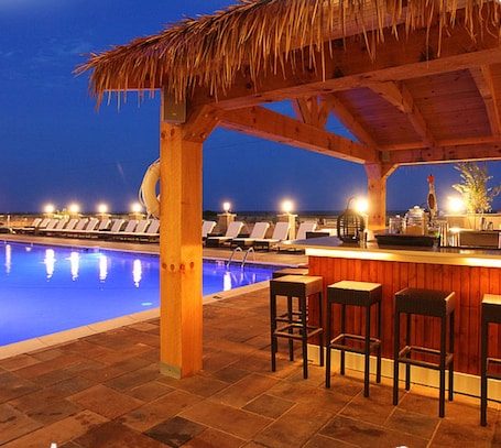 An outdoor pool area with lounge chairs and a bar.