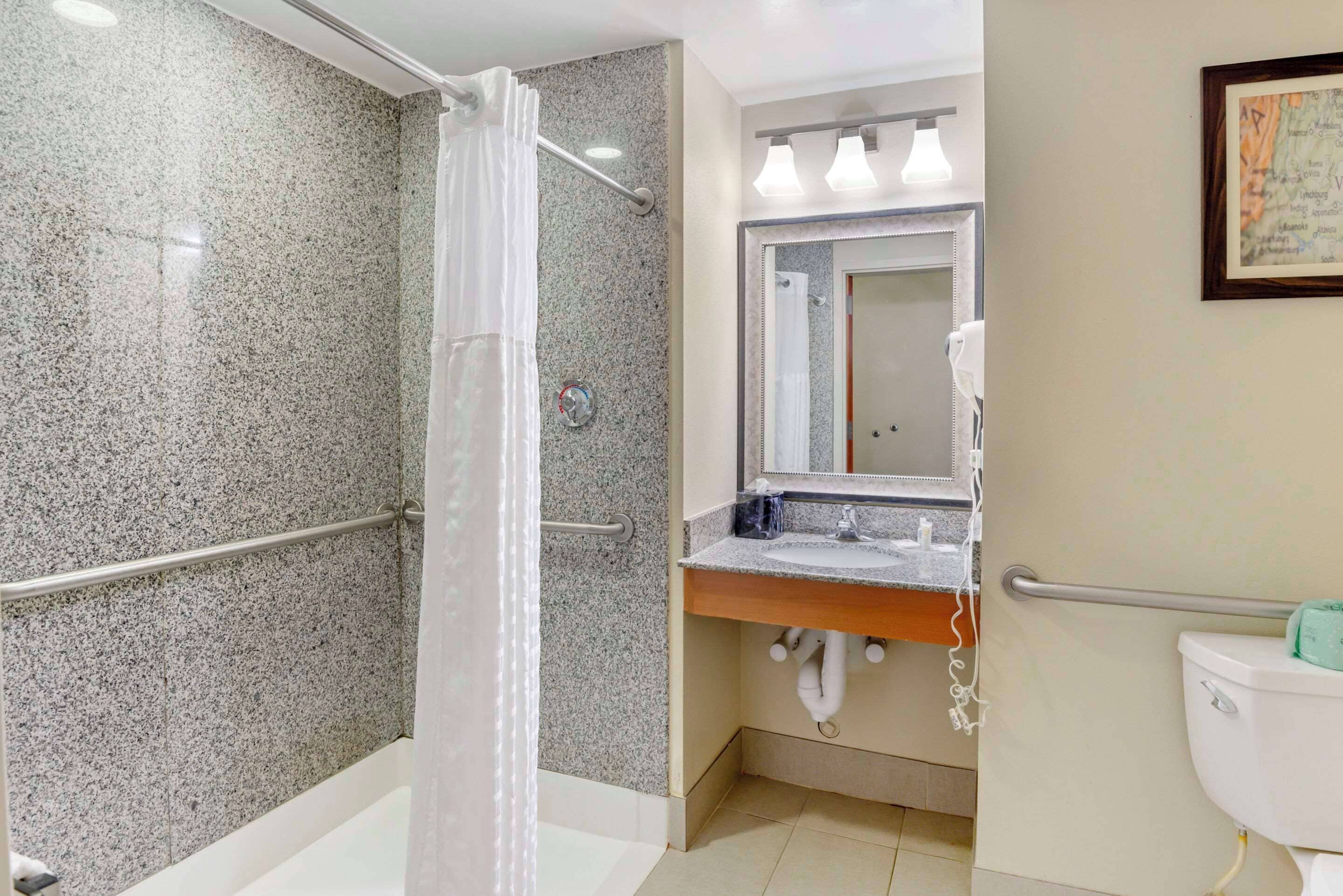 Un baño con ducha, lavamanos, inodoro y espejo.