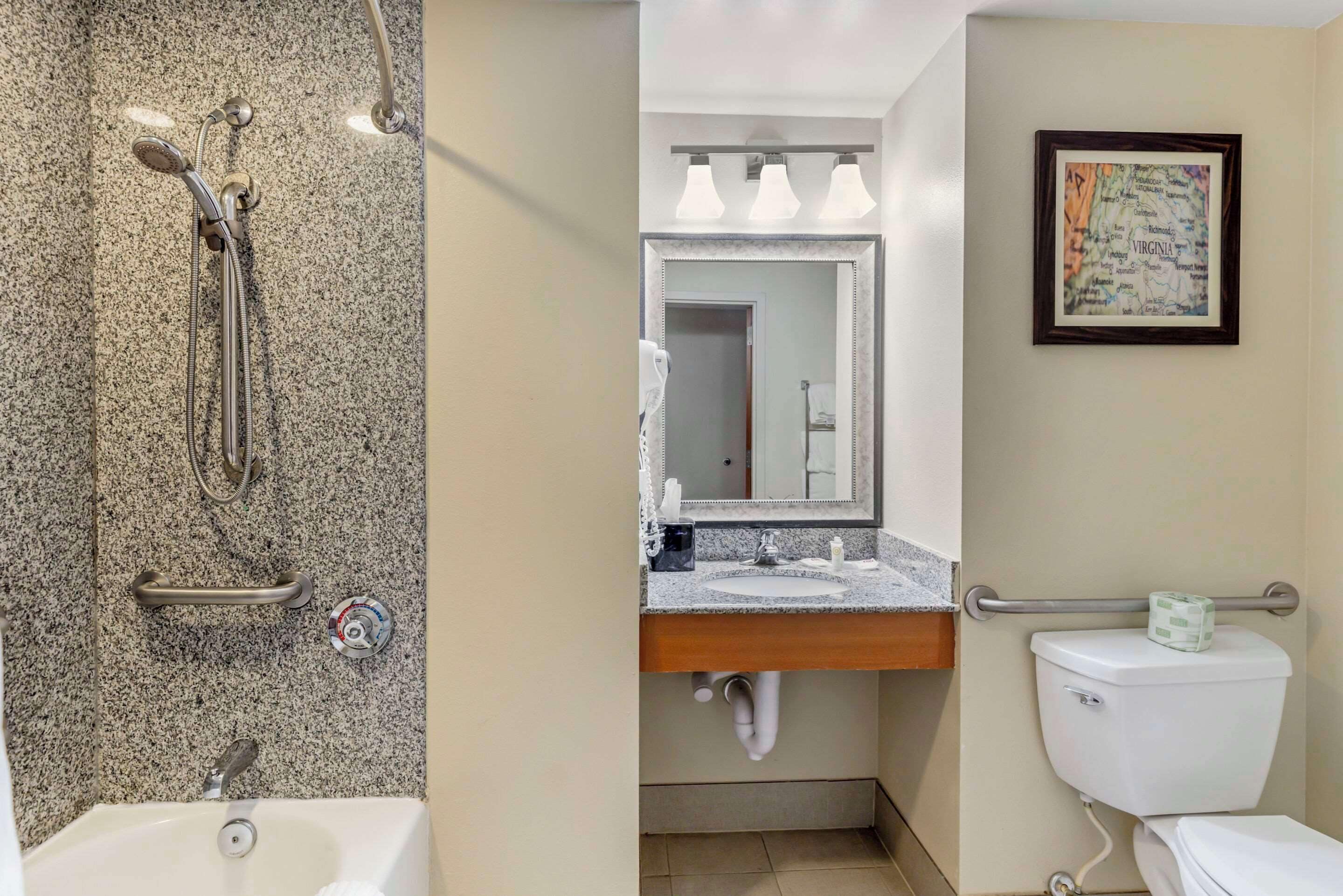 Une salle de bain avec une douche en granit, un lavabo avec un miroir et des toilettes.