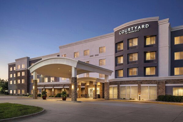 A Courtyard by Marriott hotel with a modern design, featuring a covered entrance and multiple floors.