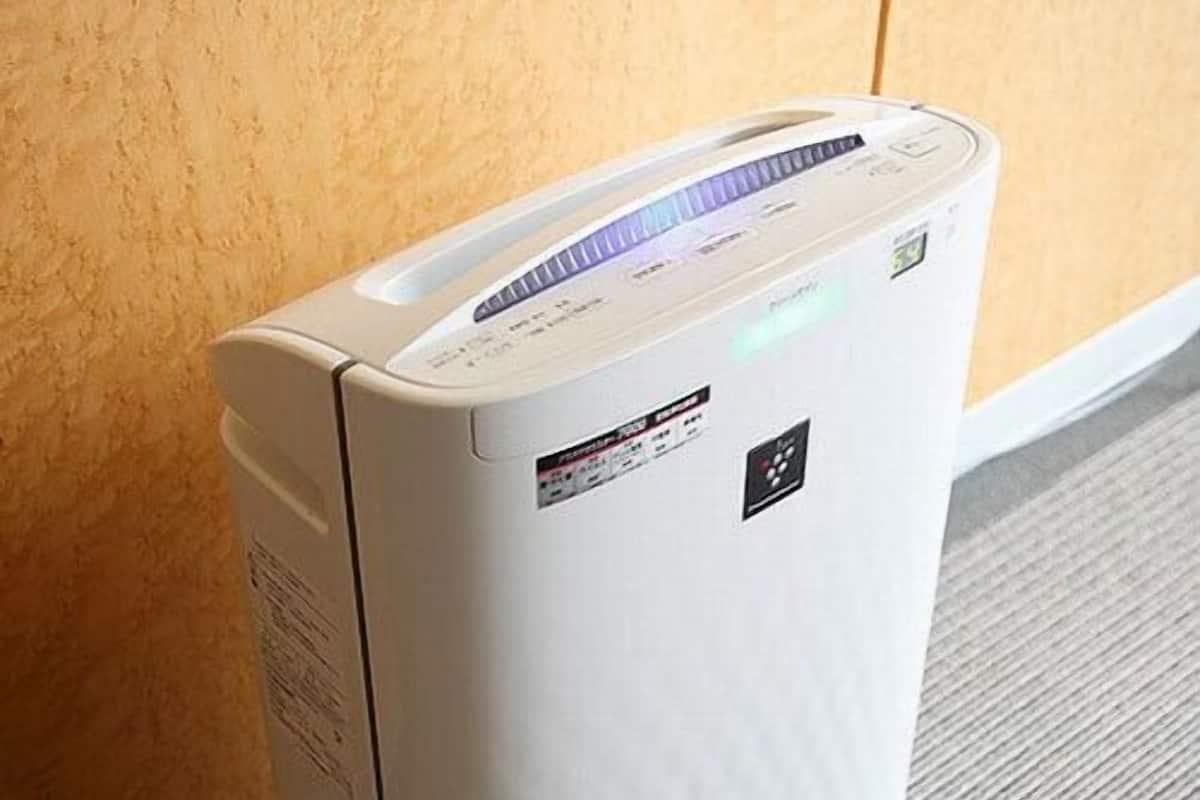 A white portable heater with a control panel, placed against a wall.