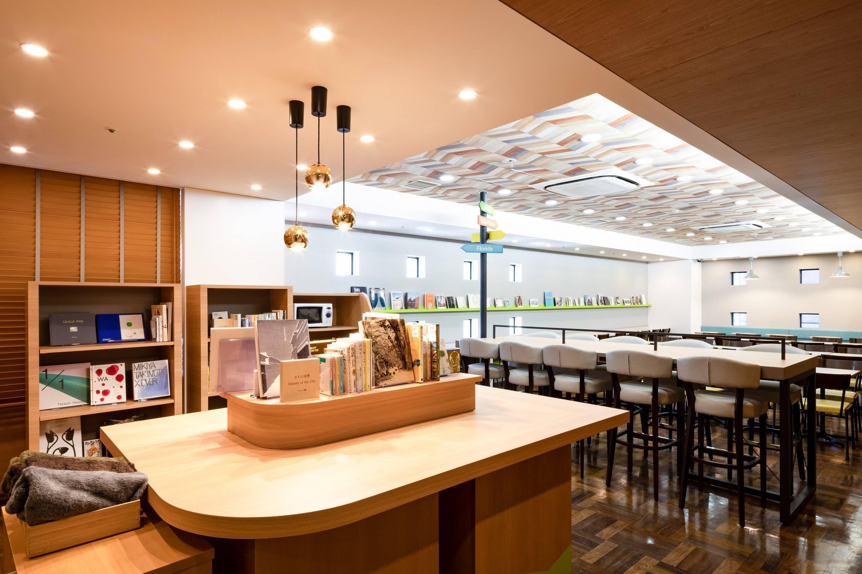 A modern library with a central reading area, bookshelves, and a ceiling with geometric patterns.