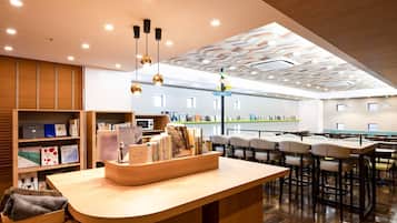 A modern library with a central reading area, bookshelves, and a ceiling with geometric patterns.