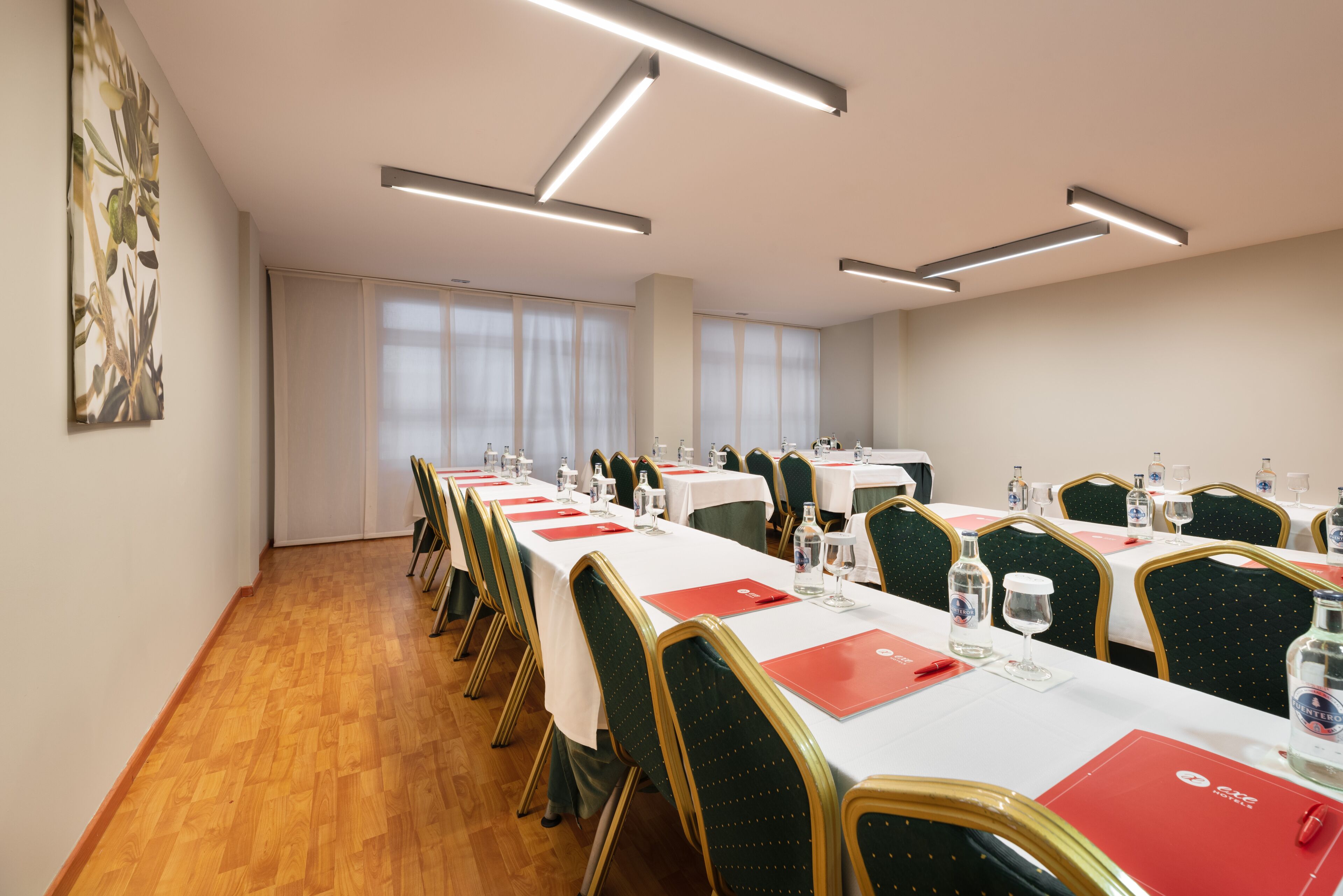 Una sala conferenze con lunghe tavolate, sedie e un'ampia finestra.