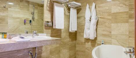 A modern bathroom with a marble sink, a large bathtub, and two towel racks.