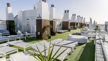 Alberca al aire libre, sombrillas en la alberca y camastros