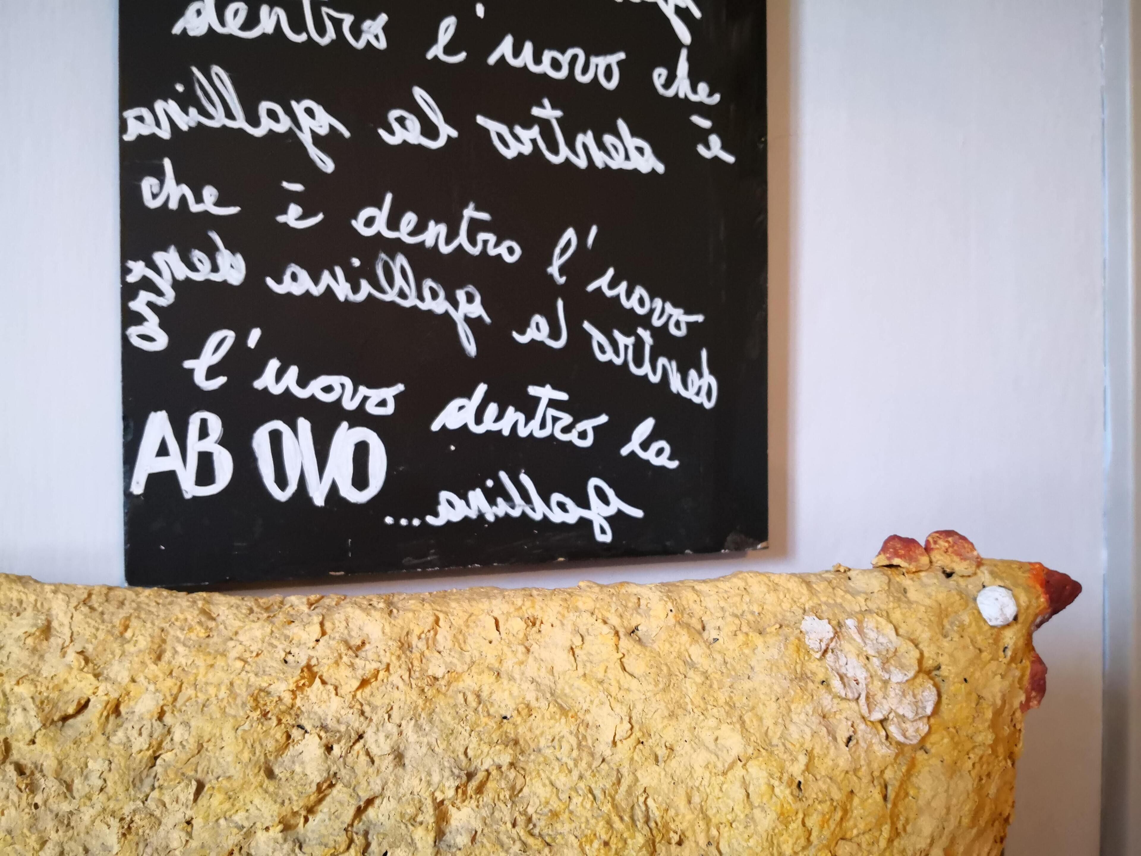 A loaf of bread with a handwritten sign in a foreign language.