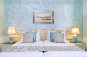 A double bed with a headboard, two bedside tables with lamps, and a framed picture on the wall. - El Oceano Beach (Mijas)