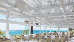 An outdoor dining area with tables set for guests, overlooking a scenic ocean view. - El Oceano Beach (Mijas)