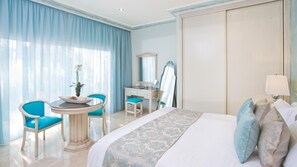 A hotel room with a bed, a desk, a chair, a mirror, and a lamp. - El Oceano Beach (Mijas)