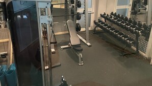 A gym with weightlifting equipment, a bench, and a mirror. - El Oceano Beach (Mijas)