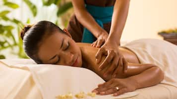 Guests can enjoy a rejuvenating massage in this serene space, featuring a comfortable bed and a peaceful atmosphere.