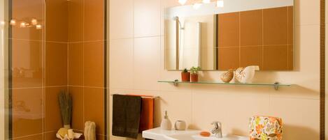 A modern bathroom with a bathtub, a sink, a mirror, and a shower.