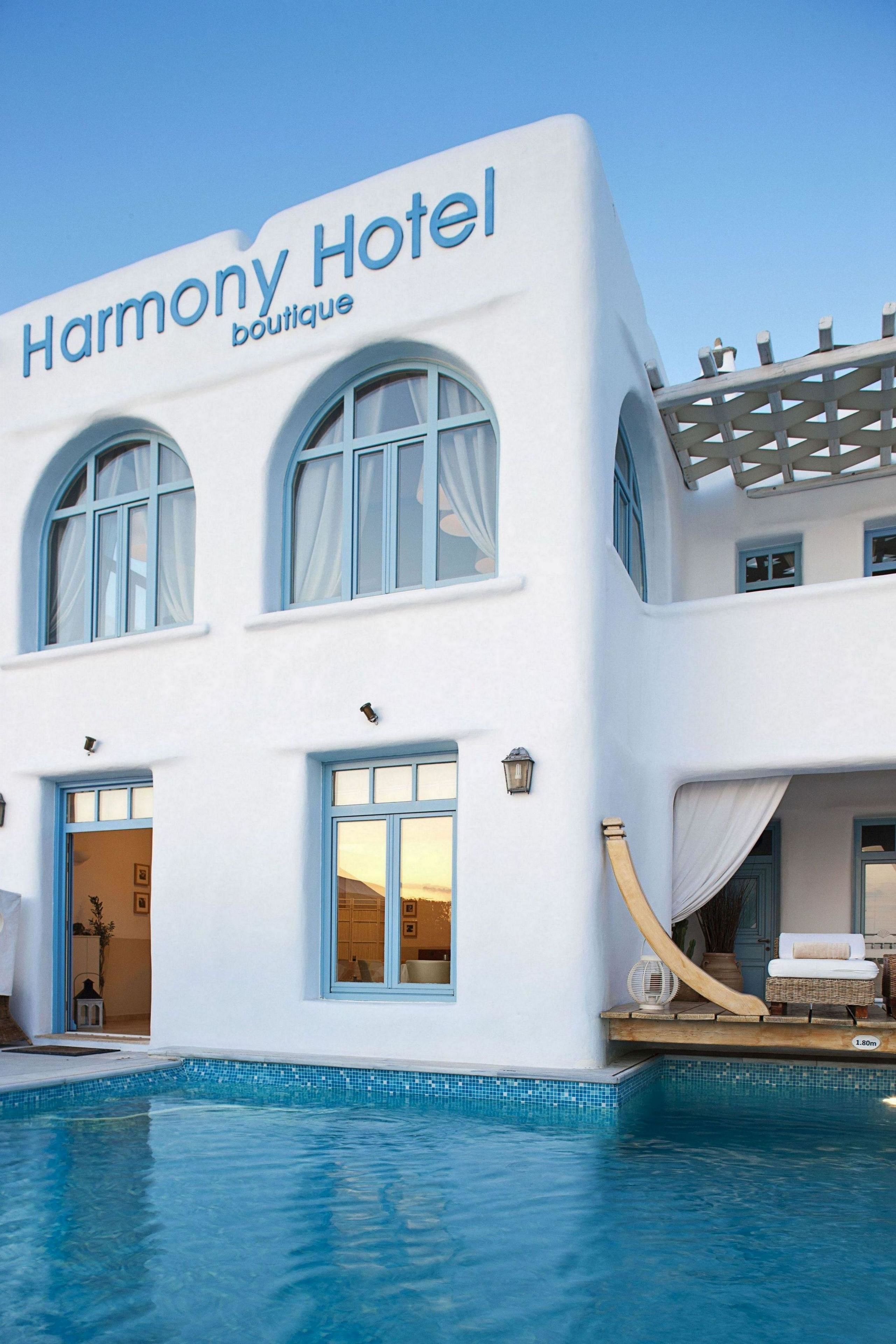 Un hotel boutique Harmony con piscina, ventanas amplias y fachada blanca.