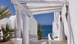 Un área de estar al aire libre con paredes blancas y vistas al mar.