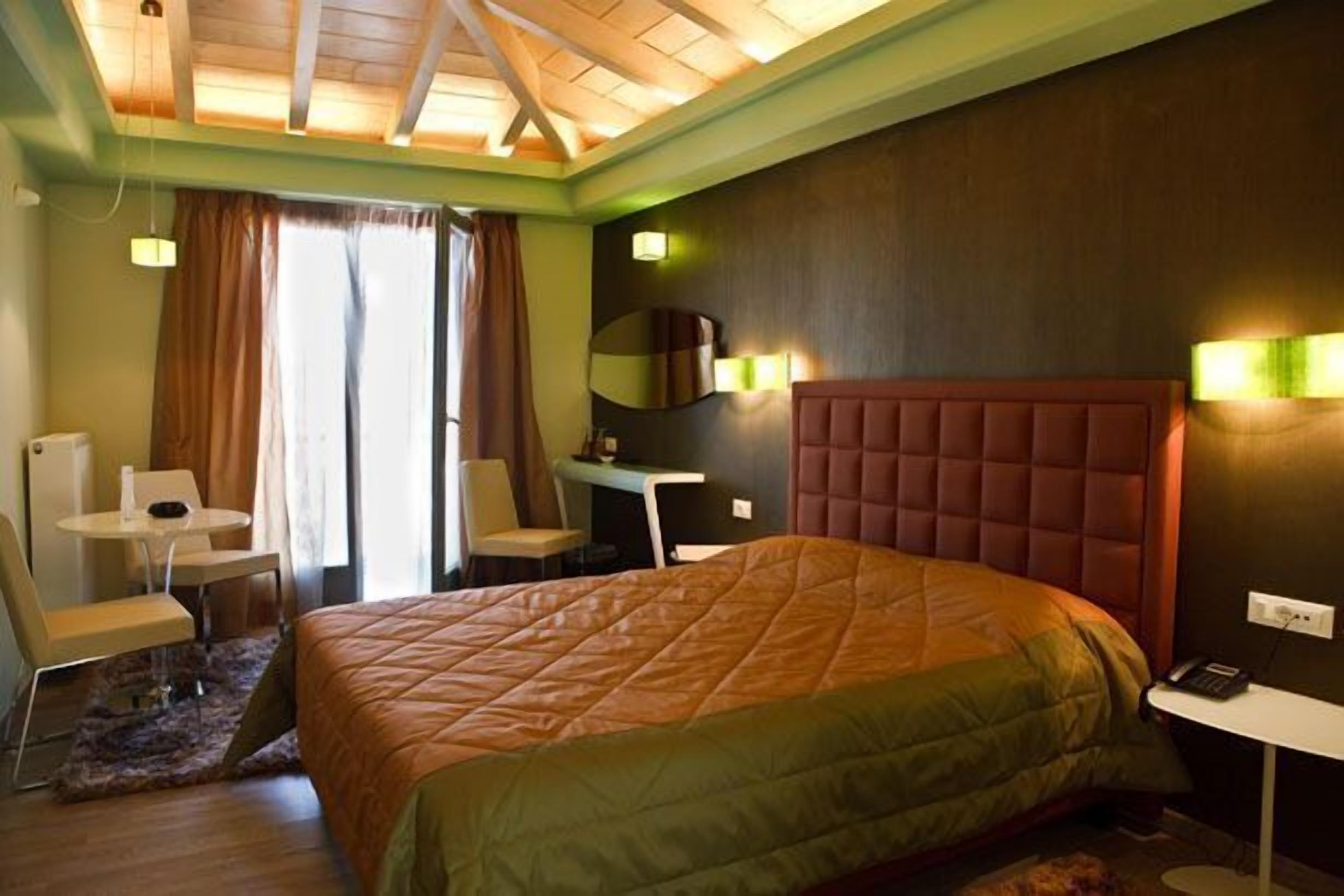 Une chambre d’hôtel avec un grand lit, un bureau, une chaise et une petite table.