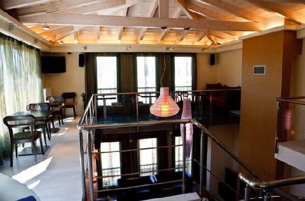 A hotel room with a balcony, a large window, and a hanging light fixture. - Amfitriti Palazzo (Nafplio)