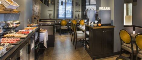 A breakfast buffet with various food items and a seating area with chairs and tables.
