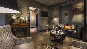 A modern living room with a fireplace, a sofa, a coffee table, and a chessboard. - Hôtel International Paris (Paris)