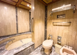 A modern bathroom with a marble vanity, a toilet, bidet, and a shower area. - Exe Alameda Reforma (Mexico City)