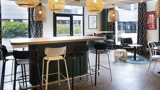 A bar area with wicker pendant lights, a bar counter, and bar stools. - Aparthotel Adagio Annecy Centre (Annecy)