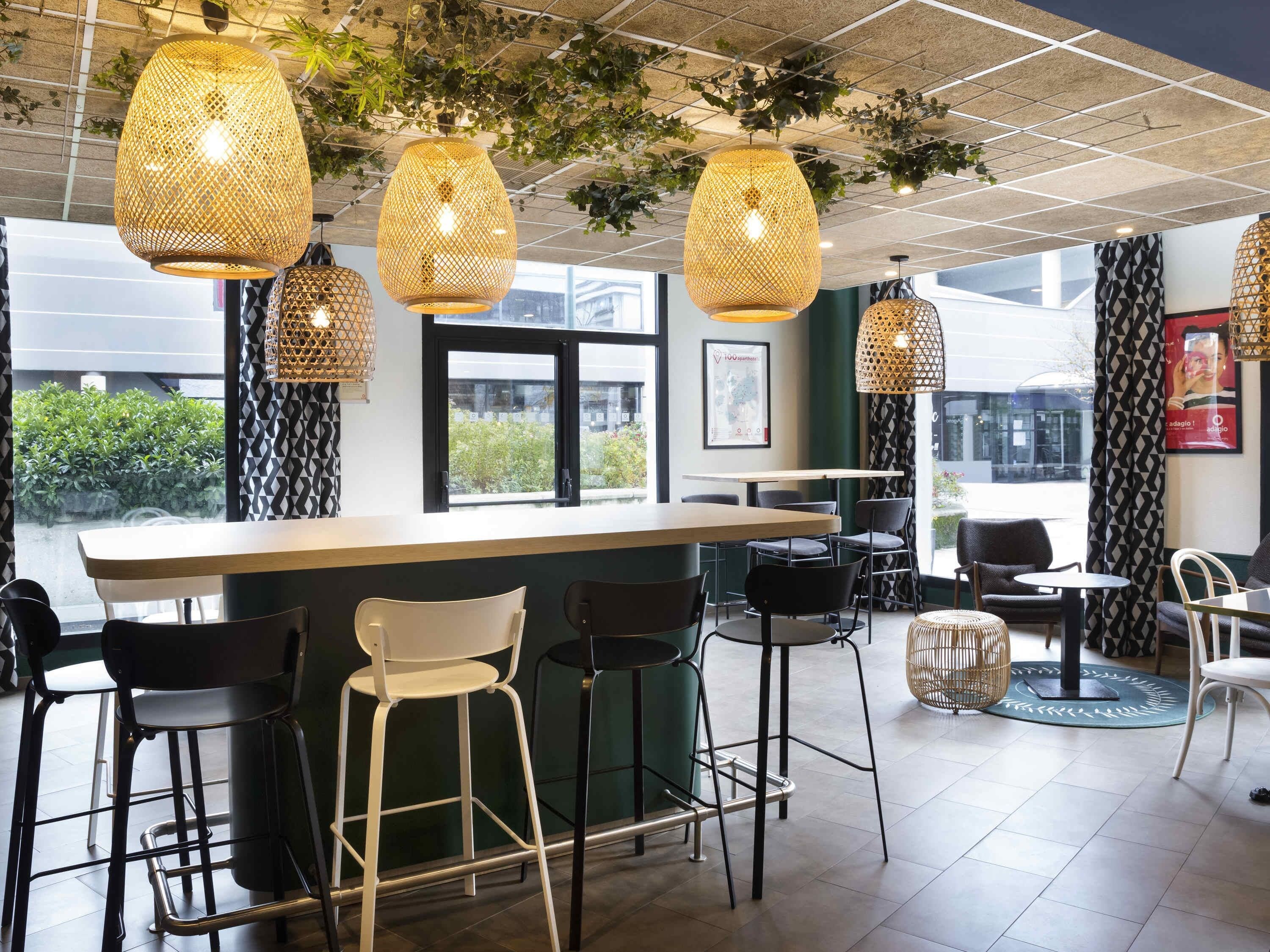 Een bar met rieten hanglampen, een bargedeelte en barstoelen.